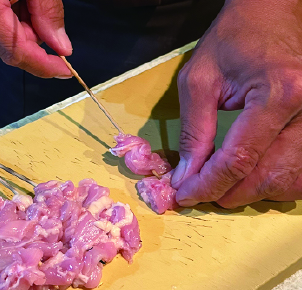 Skewering chicken for yakitori